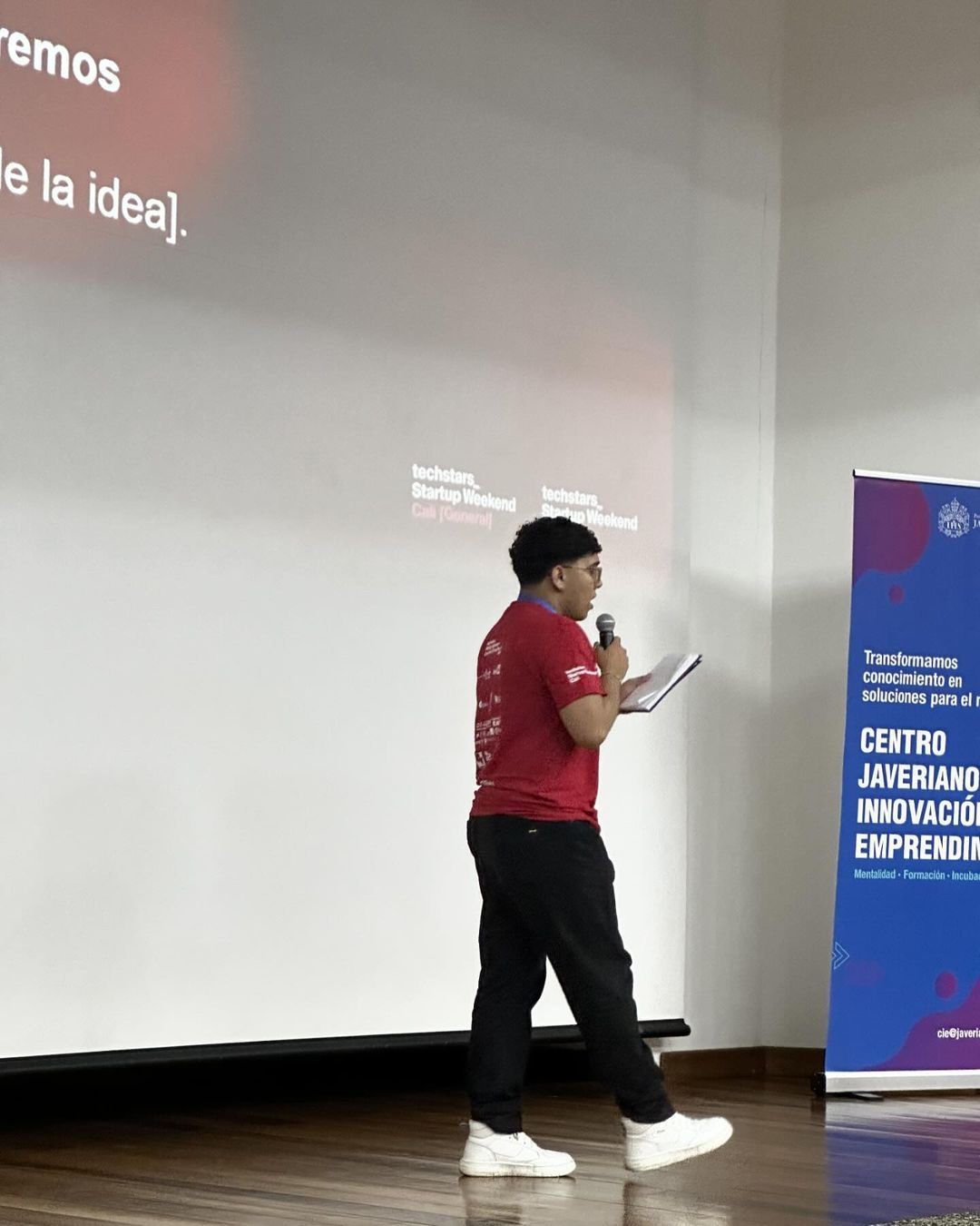 Integrante del equipo presentando la idea en el auditorio